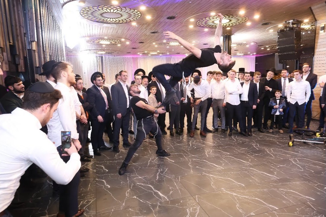 פעלולן של האחים קהן מסתובב באוויר במרכז מעגל רוקדים בחתונה